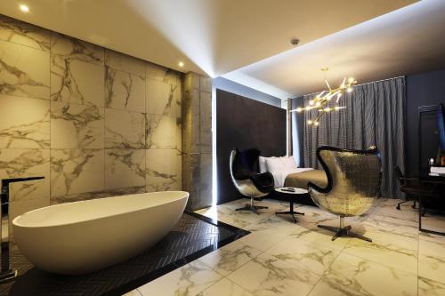 a bathroom with a tub and two chairs and a desk at Cheonan La Tree Hotel in Cheonan