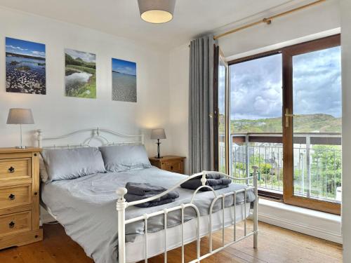 a bedroom with a bed and a large window at Apartment 514 - Clifden in Clifden