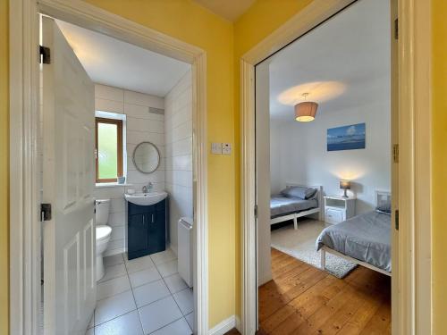 a bathroom with a sink and a toilet and a bed at Apartment 514 - Clifden in Clifden