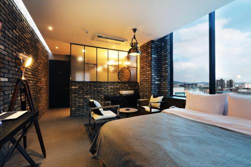 a bedroom with a large bed and a large window at Cheonan La Tree Hotel in Cheonan