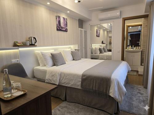 a hotel room with a large bed and a desk at Studio MD in Chişinău