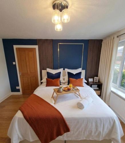 a bedroom with a large bed with a table on it at Modern Large 5-Bed-2 Baths-Parking-Great for Groups-Contractors-Families-Royal Leamington Spa-Warwickshire-By The Home Makers Hub in Leamington Spa