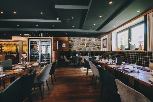 a restaurant with wooden tables and chairs and a bar at Hotel Kaprunerhof in Kaprun