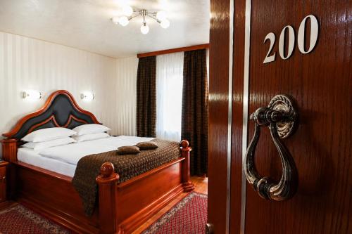 a bedroom with a bed and a door with the number at Vila Prezident in Sremski Karlovci