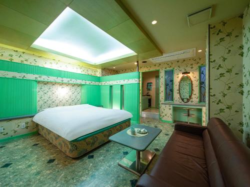 a bedroom with a large bed and a couch at HOTEL WiLL 大高 レジャーホテル in Nagoya