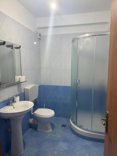 a bathroom with a toilet and a glass shower at Shëngjin Beach Nest in Lezhë