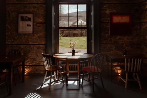 a table and chairs in a room with a window at Suie Hunting Lodge in Killin