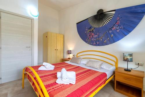 a bedroom with a bed with towels on it at Villa Rosa Sea View in Valledoria