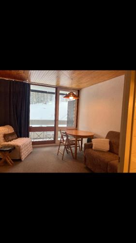 a living room with a table and a couch and a table at Studio pied de piste Pelvoux 2 in Vars