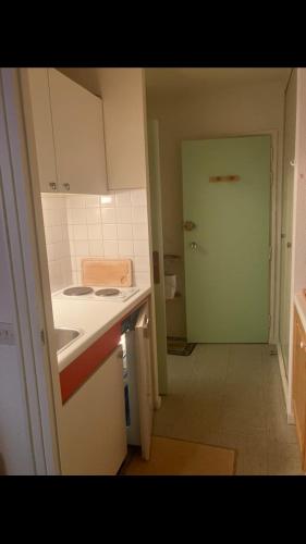 a kitchen with a counter and a sink and a door at Studio pied de piste Pelvoux 2 in Vars