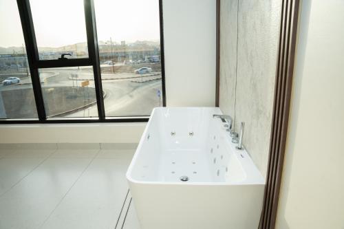 a white sink in a bathroom with a window at Horizon Stay Nizwa in Firq