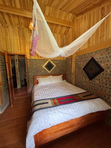 a bed in a room with a wooden ceiling at Chacha's House in Sapa