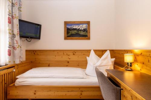 a room with a bed and a desk with a desk at Alpenperle in Ramsau am Dachstein