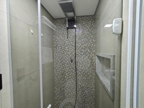 a bathroom with a shower with a glass door at Flat 113, Hotel Cavalinho Branco in Águas de Lindoia