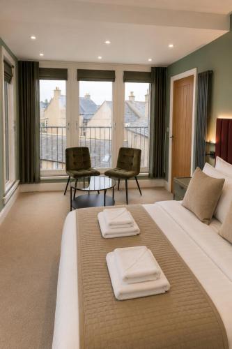 a large bedroom with a large bed with two chairs at The View from BIDE in Thurso