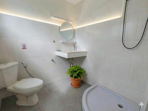 a white bathroom with a toilet and a sink at Casa Srithanu in Ko Phangan