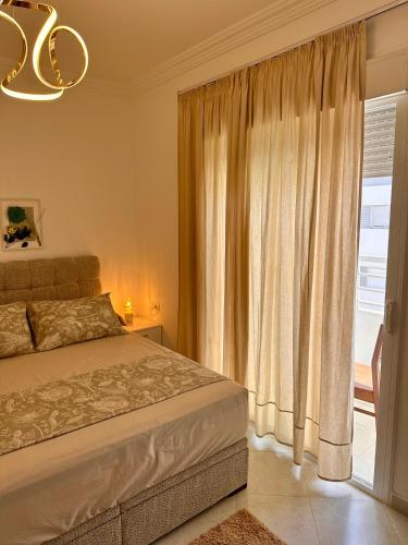 a bedroom with a bed and a large window at Modern Comfort Stay Tanger in Tangier