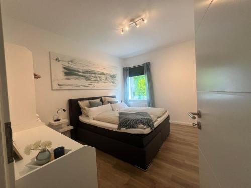 a bedroom with a bed in a room with a window at Ferienwohnung M2 in Husby