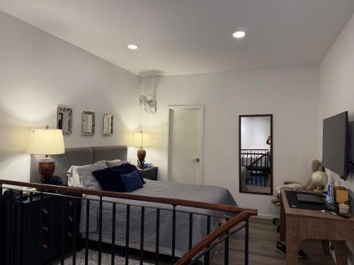 a bedroom with a bed and a desk with a lamp at Charming and Relaxing Home in Guatemala