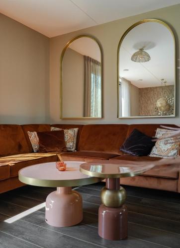 a living room with a couch and a table and mirrors at Parc La Dune Marrakesh Lodge in Warmenhuizen