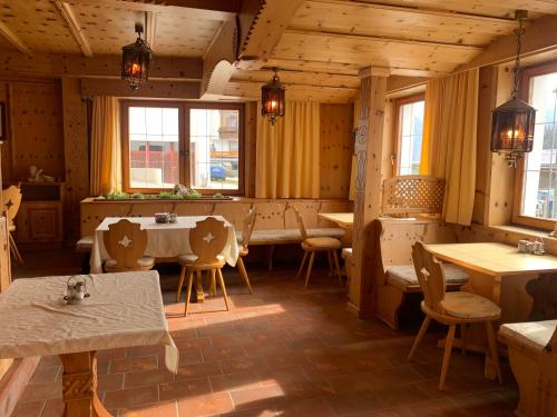a restaurant with wooden walls and tables and windows at Tirolerhof - inklusive Super Sommer Card in Serfaus