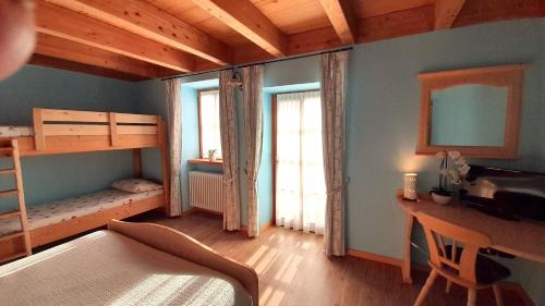 a bedroom with bunk beds and a desk and a desk at Chalet Dolomiti Trentino in Sant’Orsola