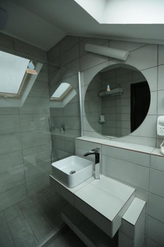 a white bathroom with a sink and a mirror at Casa Domnească Cacica in Cacica