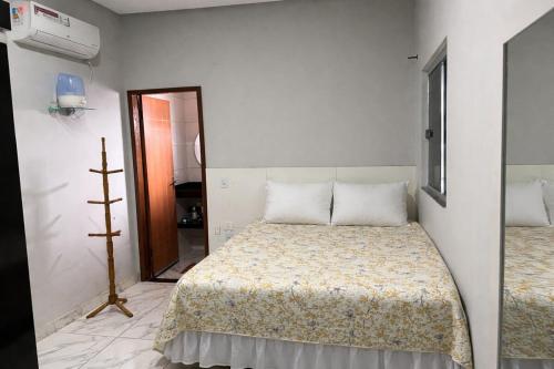 a white room with a bed and a mirror at Casa para temporada em SRN in São Raimundo Nonato