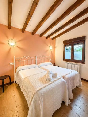 a bedroom with a large bed with white sheets at Alojamientos Fermín in Cangas de Onís
