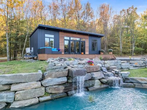 ein winziges Haus mit einem Wasserfall im Garten in der Unterkunft Tiny House on a Waterfall at Private Tiny Lake in Brackney