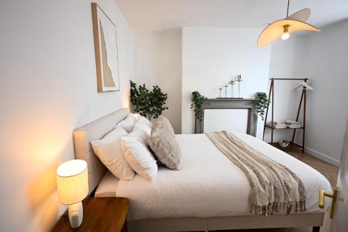 a bedroom with a bed with white sheets and pillows at Kent House in Ramsgate