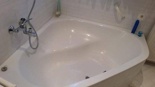 a white bath tub with a faucet in a bathroom at Apartment Tatjana in Ljubljana