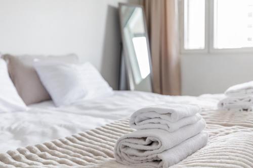a pile of towels sitting on a bed at Central Studio I by Elys Collection in Rovaniemi