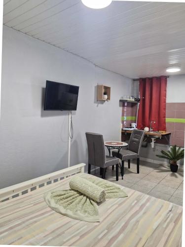 a living room with a tv and a table and chairs at Cayenne MIRZA 2 Confort T2 in Cayenne