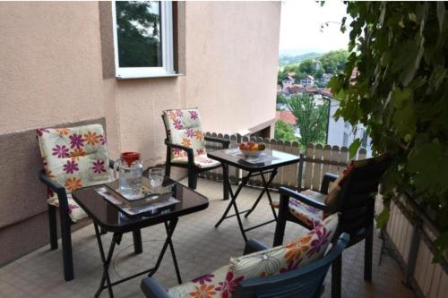 a patio with chairs and tables and a balcony with a view at Apartments Mensa in Tuzla
