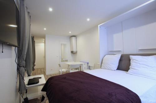 a bedroom with a large bed and a table at Top Studio SV1020 Centre Vincennes 20M2 in Vincennes