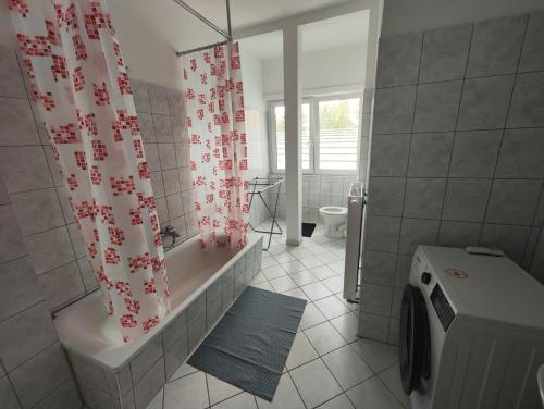 a bathroom with a tub and a shower curtain at Revant West 2 in Arnstadt