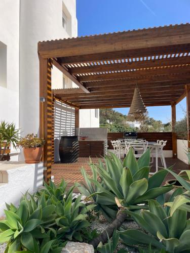 a patio with a wooden pergola and a table at Casa Bonic -Sunset Seaview in Sant Josep de sa Talaia