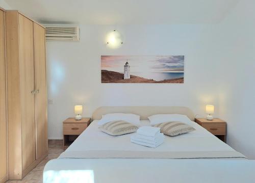 a bedroom with a white bed and a lighthouse at Villa Grace Felice in Fažana