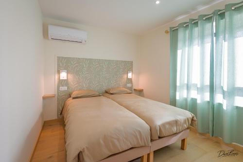 a bed in a room with a large window at Domaine de cézille-Appart hôtel le Moulin du lac "Paul" in Jayat