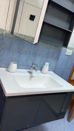 a bathroom sink with two cups on top of it at Spacious Coastal Retreat - Golem Beach Near Durrës in Golem