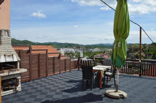 a patio with an umbrella and a table and chairs at Apartments Mensa in Tuzla