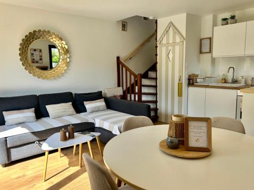 a living room with a couch and a table at Le Cottage D'Ilona in Blonville-sur-Mer