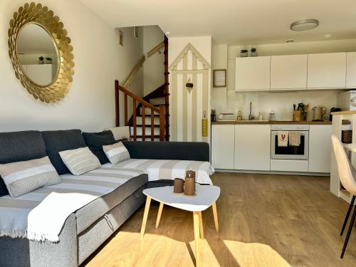 a living room with a couch and a table at Le Cottage D'Ilona in Blonville-sur-Mer