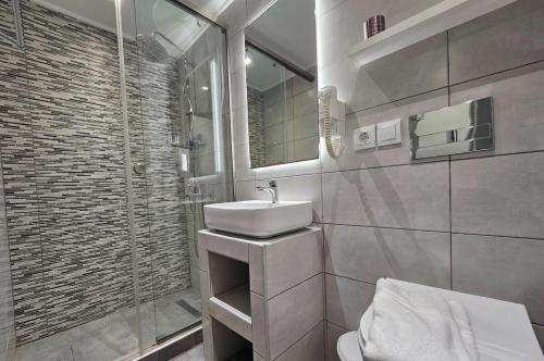 a white bathroom with a sink and a shower at Pals Studios Pefkos in Pefki