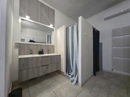a bathroom with a sink and a mirror at Cocon des Arènes Nîmes Centre 18 couchages in Nîmes