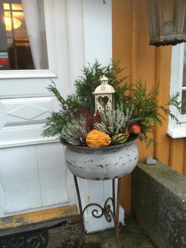 a flower pot with a centerpiece of vegetables and a lantern at Bergsmansgårdens Gästhus in Asphyttan