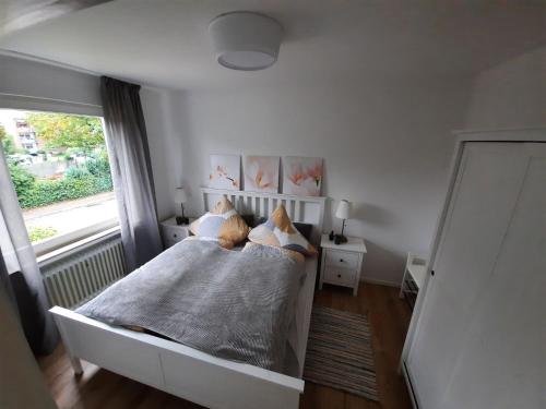 a bedroom with a white bed and a window at Rikes Ferienwohnung 2 in Heinsberg