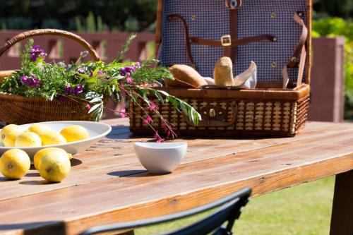 a wooden table with a basket of lemons on it at Amandola Villas in Ayia anna