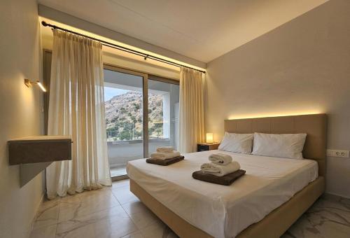 a bedroom with a large bed with towels on it at Pals Studios Pefkos in Pefki